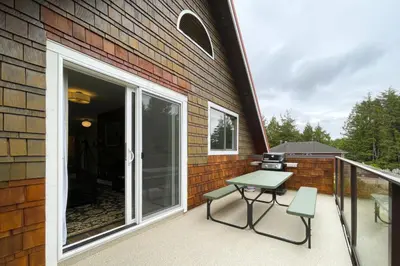 a patio with a table and chairs on a balcony at Raven Lady #201- Ucluelet Sleeps 6 Pet Friendly in Ucluelet