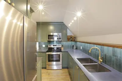 a kitchen with green cabinets and stainless steel appliances at Raven Lady #202- Ucluelet, Sleeps 4, Pet Friendly in Ucluelet