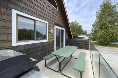 a patio with a table and chairs and a window at Raven Lady #202- Ucluelet, Sleeps 4, Pet Friendly in Ucluelet