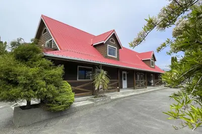 a house with a red roof and a driveway at Raven Lady #202- Ucluelet, Sleeps 4, Pet Friendly in Ucluelet