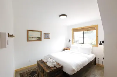 a bedroom with a white bed and a window at Raven Lady #202- Ucluelet, Sleeps 4, Pet Friendly in Ucluelet