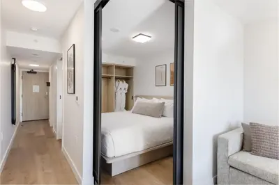 a bedroom with a white bed and a mirror at Keefer House in Vancouver