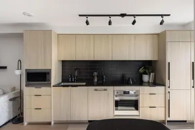 a kitchen with wooden cabinets and black appliances at Keefer House in Vancouver