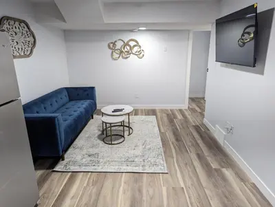 a living room with a blue couch and a table at Chic 2BR Suite with Kitchen, Laundry, Near Elk Island & West Edmonton Mall in Edmonton