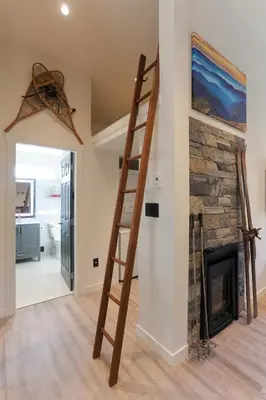 a living room with a fireplace and a wooden ladder at 