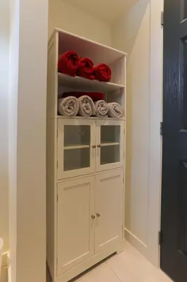 a closet with a white cabinet filled with towels at 