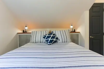 a bed with blue and white striped sheets and two pillows at 