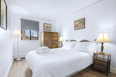 a bedroom with a large white bed and two lamps at Stylish Suite at Stampede w Free Parking and AC in Calgary