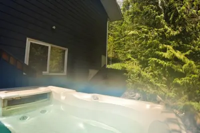 a bath tub in front of a house at Dog friendly Home on Ski Hill with Hot Tub by StayIn in Fernie