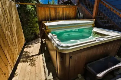 a bath tub with a pool of green water at Dog friendly Home on Ski Hill with Hot Tub by StayIn in Fernie