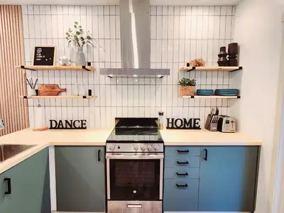 a kitchen with blue cabinets and a stove at The OVERLOOK Stay-Mountain View-Free Parking in Canmore