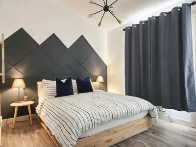 a bedroom with a large bed with blue pillows at The OVERLOOK Stay-Mountain View-Free Parking in Canmore