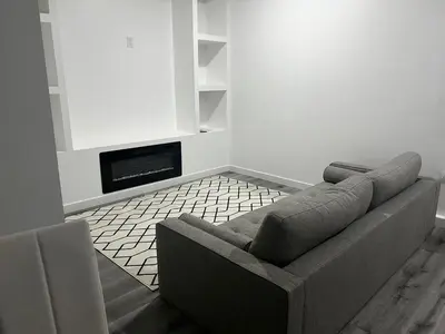 a living room with a couch and a fireplace at Basement in Keswick Edmonton in Edmonton