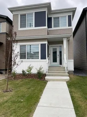 a house with a blue door and a sidewalk at Basement in Keswick Edmonton in Edmonton