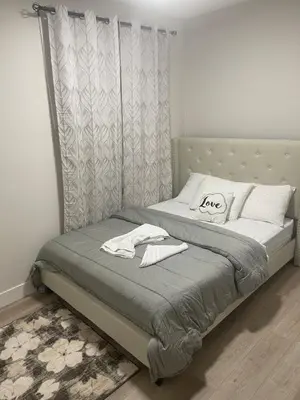 a bed with two white towels on top of it at Modern suite in basement Upland in Edmonton