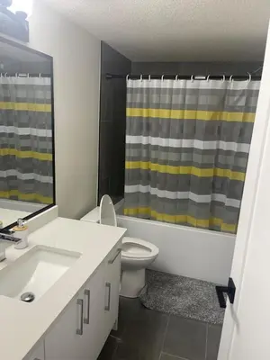 a bathroom with a sink and a toilet and a shower at Modern suite in basement Upland in Edmonton