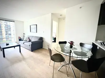 a living room with a table and chairs and a couch at Fabulous and convenient 2B2B close to Richmond center in Richmond