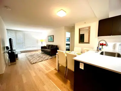 a living room with a kitchen and a living room with a couch at Fantastic and comfortable 2B2B center of Richmond in Richmond