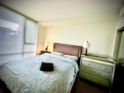 a bedroom with a bed and a dresser and a window at Fantastic and comfortable 2B2B center of Richmond in Richmond