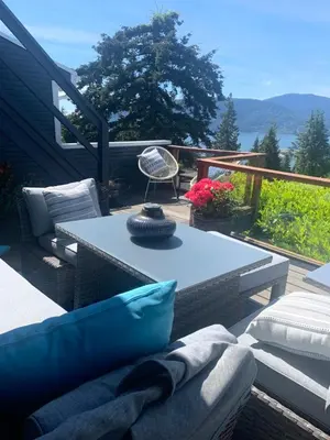 a patio with a table and a chair on a deck at West Vancouver 3 bedroom Spacious Very Well Maintained Close to Ocean Mts Hikes Golf Shopping City Whistler in West Vancouver