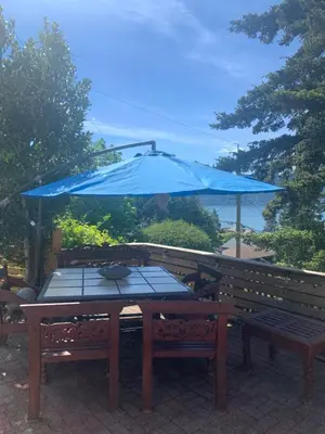 a picnic table with a blue umbrella on top at West Vancouver 3 bedroom Spacious Very Well Maintained Close to Ocean Mts Hikes Golf Shopping City Whistler in West Vancouver
