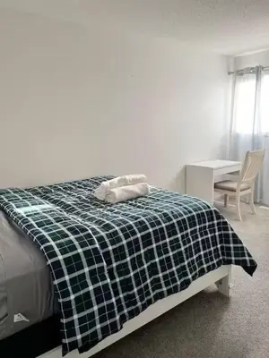 a bedroom with a bed with a black and white blanket at Bedroom in Southwest A in Edmonton