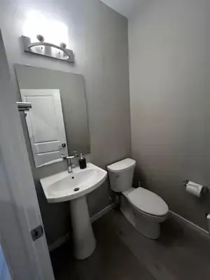 a white bathroom with a toilet and a sink at Bedroom in Southwest A in Edmonton