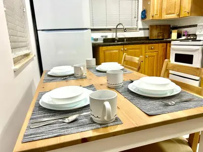 a kitchen with a wooden table with plates and mugs at Cozy 2-bedroom Private Guest House in a convenient location in Vancouver