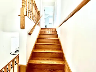 a staircase in a house with wooden floors at Cozy 2-bedroom Private Guest House in a convenient location in Vancouver