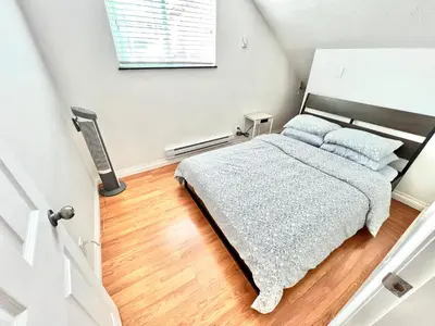 a bedroom with a bed with blue pillows at Cozy 2-bedroom Private Guest House in a convenient location in Vancouver