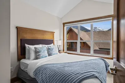 a bedroom with a bed and a large window at Peaks and Patio 3 Bedroom managed by Little Sister Getaways in Canmore