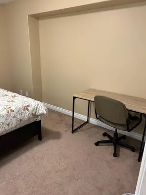 a bedroom with a desk and a chair next to a bed at Ogden 3-Bed Home in Calgary