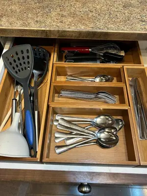 a wooden drawer with utensils in a cabinet at Ogden 3-Bed Home in Calgary