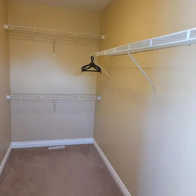 a walk in closet with white walls and shelves at Ogden 3-Bed Home in Calgary
