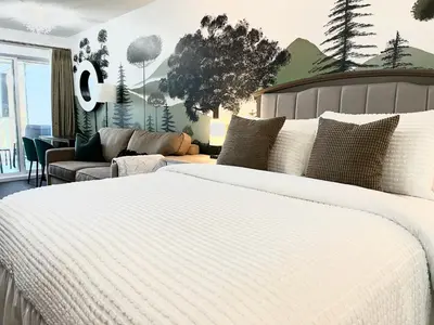 a bedroom with a white bed and a couch at Old Forest Resort Suite Heated Pool Hot Tub Sauna Beach Vancouver Island in Nanoose Bay