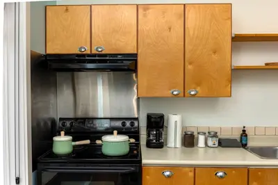 a kitchen with wooden cabinets and a stove top oven at Tofino Waterfront Condo in Tofino