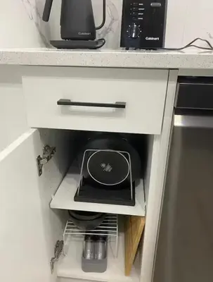 a drawer in a kitchen cabinet with a microwave at Carrington Cozy Suite, Calgary in Calgary