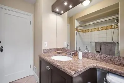 a bathroom with a sink and a large mirror at Lovely 2 Bedroom Kits Home - Walk to the Beach in Vancouver