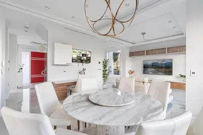 a dining room with a marble table and white chairs at Centrally Located Luxury Home with Views and Cinema in Vancouver