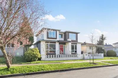 a house with a white fence on a street at Centrally Located Luxury Home with Views and Cinema in Vancouver