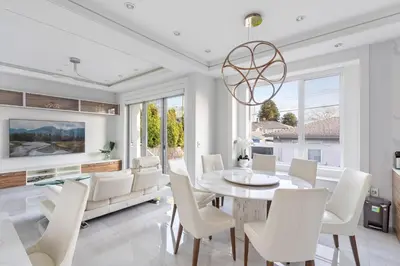 a dining room with a table and white chairs at Centrally Located Luxury Home with Views and Cinema in Vancouver