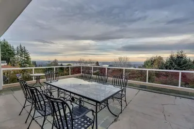 a patio with a table and chairs on a balcony at The West Vancouver Getaway Estate 5 Bedrooms in West Vancouver