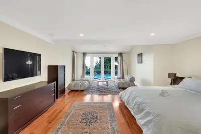 a bedroom with a large bed and a flat screen tv at The West Vancouver Getaway Estate 5 Bedrooms in West Vancouver