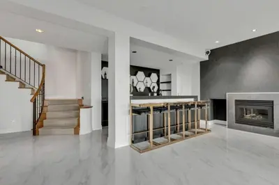 a living room with a fireplace and a staircase at Beautiful 5 bedroom West Vancouver Mansion in West Vancouver