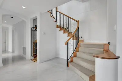 a staircase in a home with white walls and white floors at Beautiful 5 bedroom West Vancouver Mansion in West Vancouver
