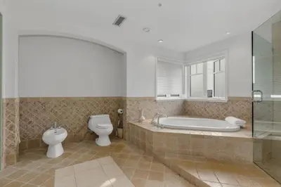 a bathroom with a tub and a toilet and a sink at Beautiful 5 bedroom West Vancouver Mansion in West Vancouver