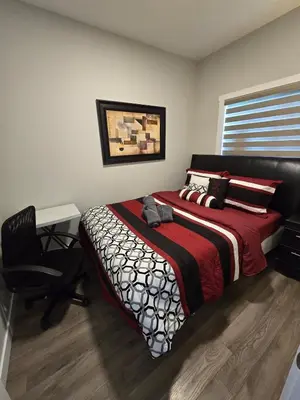a bedroom with a bed and a desk and a chair at Cornerstone 4-Bed Home in Calgary