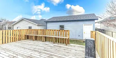 a wooden deck in front of a house at Magnificent 3-Bed Home in Calgary
