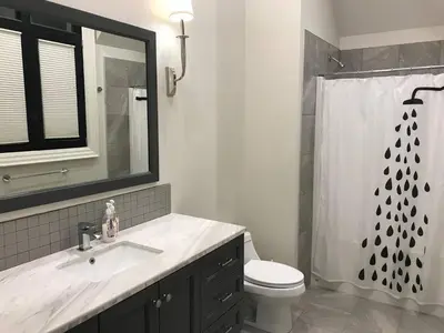 a bathroom with a sink and a toilet and a shower at Chateau Calcaire Carriage House in Kelowna