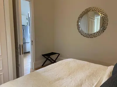 a bedroom with a bed and a mirror on the wall at Chateau Calcaire Carriage House in Kelowna